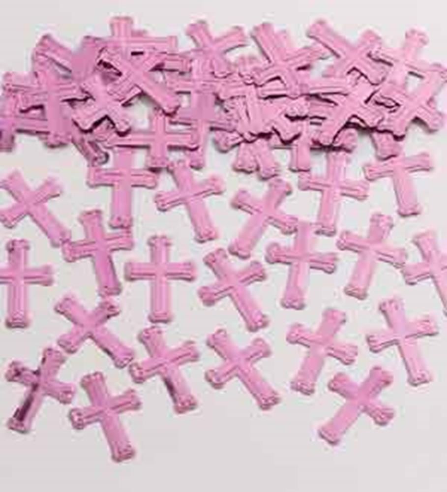 Small pink wooden crosses with a matte finish scattered on a white surface.
