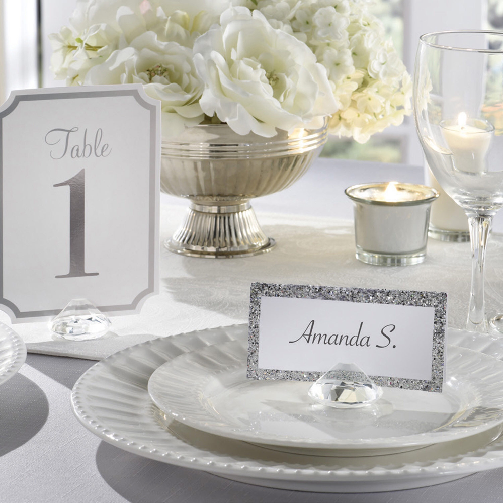 Clear glass gem-shaped table number holder displaying a white table number card with gray border and black text.