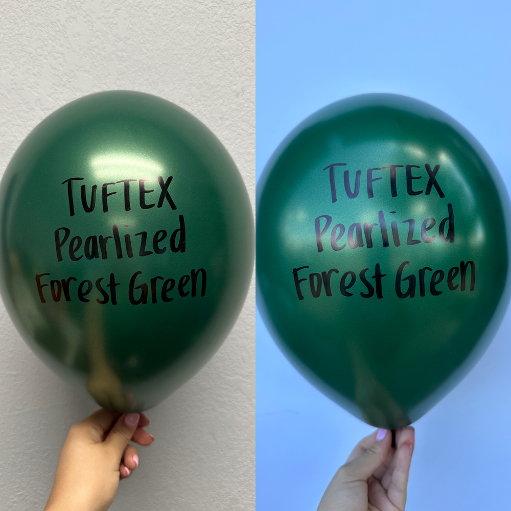 Shiny metallic forest green latex balloon with a smooth pearlized finish, 11 inches, held by a hand against plain.