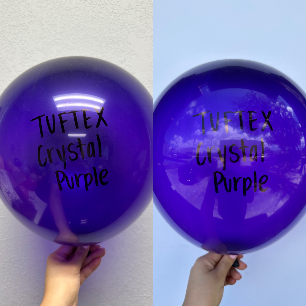 Two shiny, deep plum purple latex balloons, 11-inch size, with "Tuftex Crystal Purple" printed on them in black text.