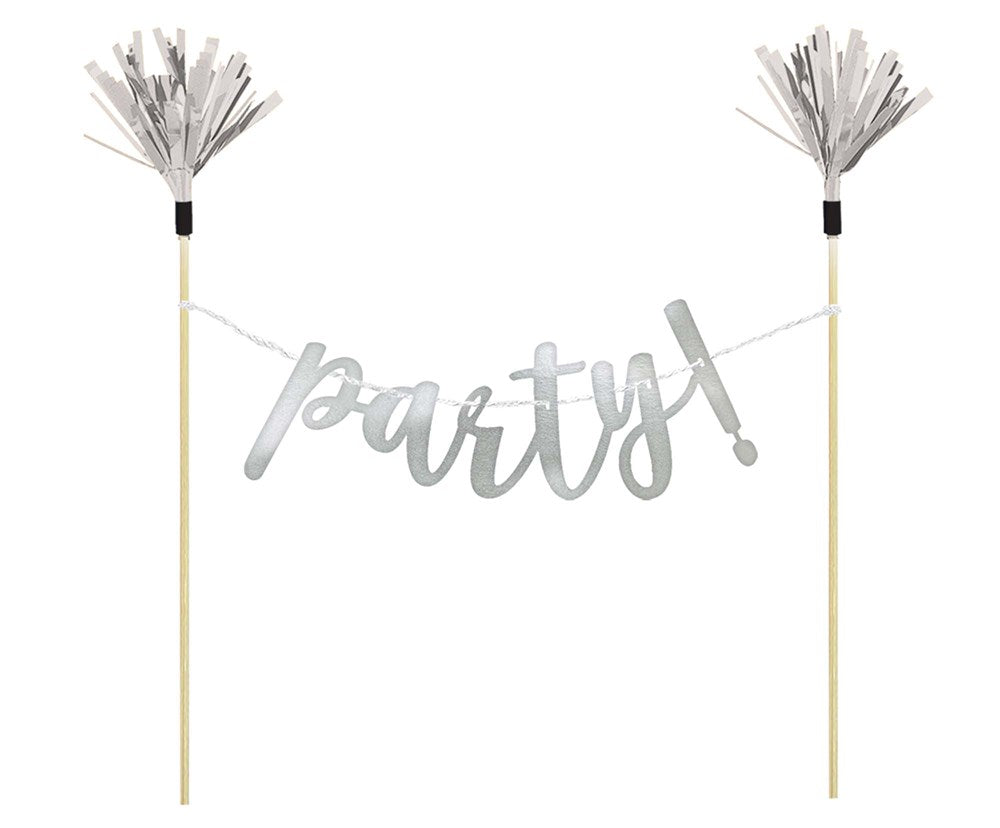 Silver metallic "party!" banner with cursive letters hanging between two wooden sticks topped with silver tassels.