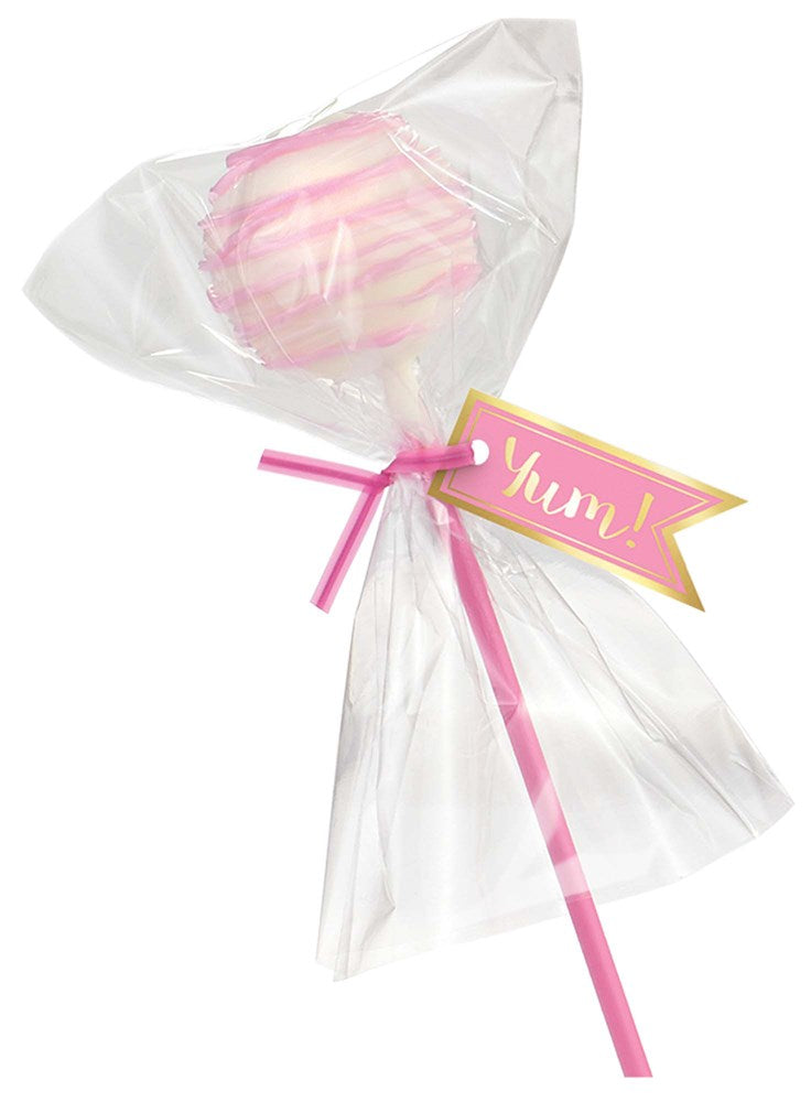Pink cake pop with white drizzle on a pink stick, wrapped in clear plastic with a pink "yum!" tag.