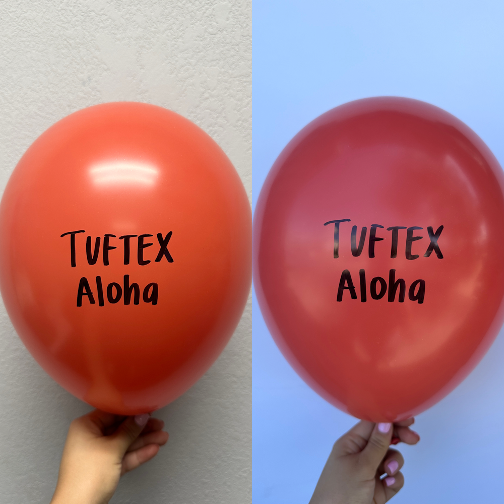 Glossy red 5-inch latex balloon with "Tuftex Aloha" printed in black, held against neutral and sky backgrounds.