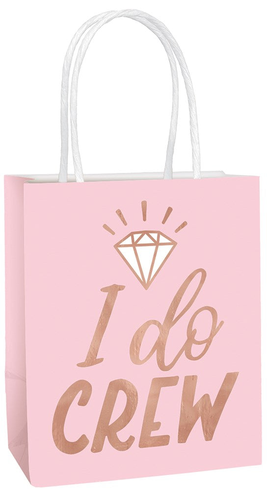 Blush pink small gift bag with white handles and rose gold foil diamond and "I do crew" text design.