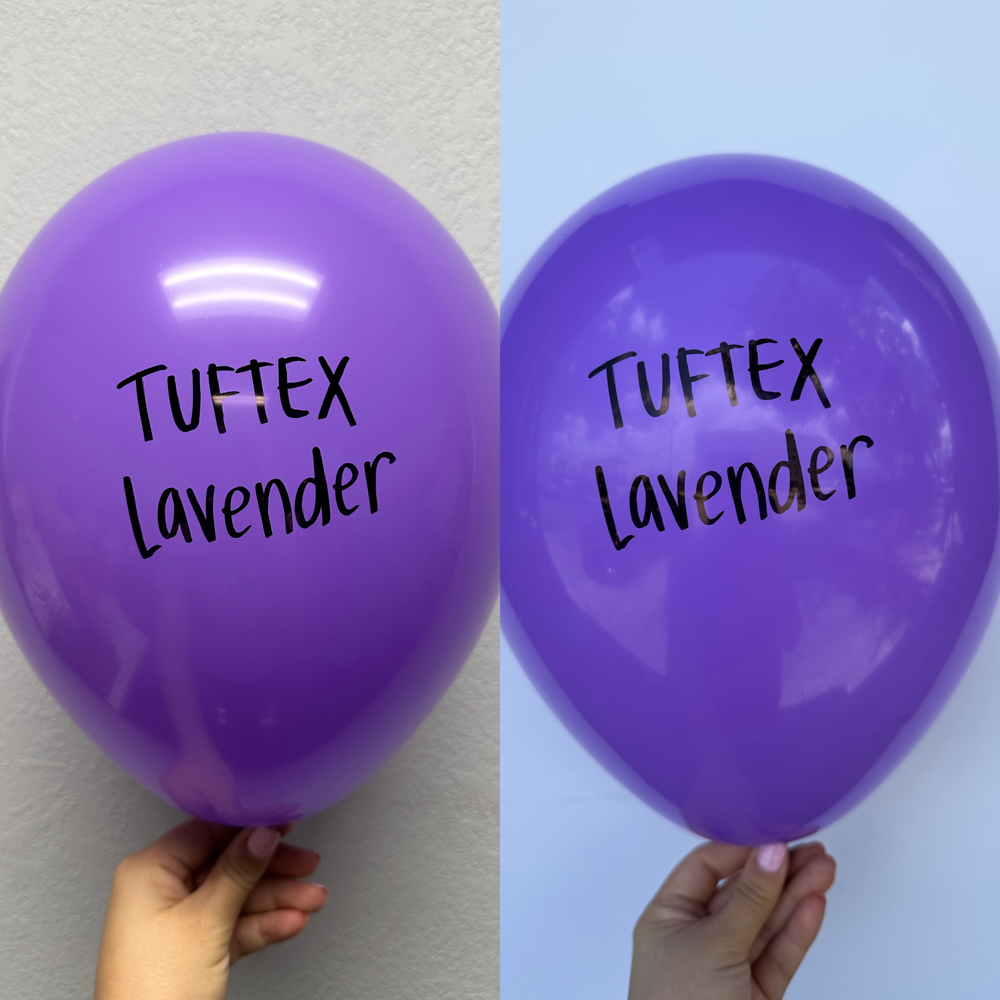 Two shiny lavender latex balloons with "Tuftex Lavender" printed in black on each, one held against a white wall.
