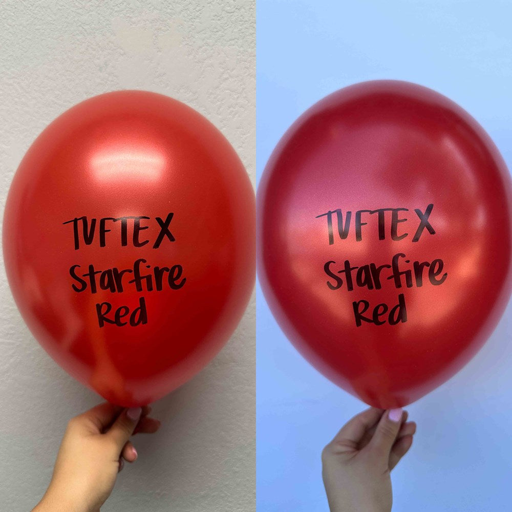 Two shiny metallic red latex balloons, 17-inch, pearlescent finish with black "Tuftex Starfire Red" text, held against plain