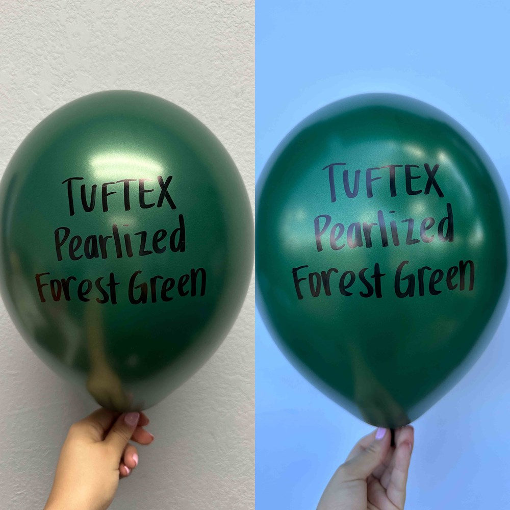 Two metallic forest green latex balloons with "Tuftex Pearlized Forest Green" printed in black on front, held against plain.
