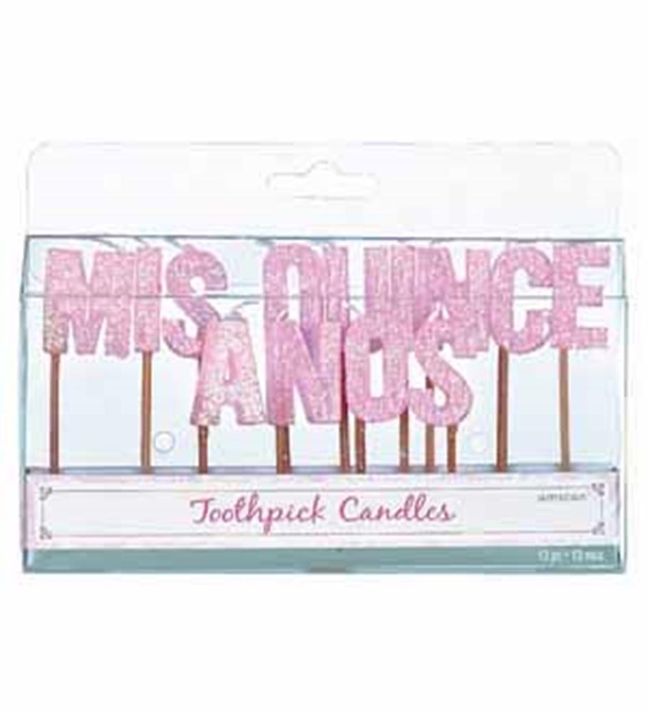 Pink glittery toothpick candles spelling "MIS QUINCE ANOS" in uppercase letters.