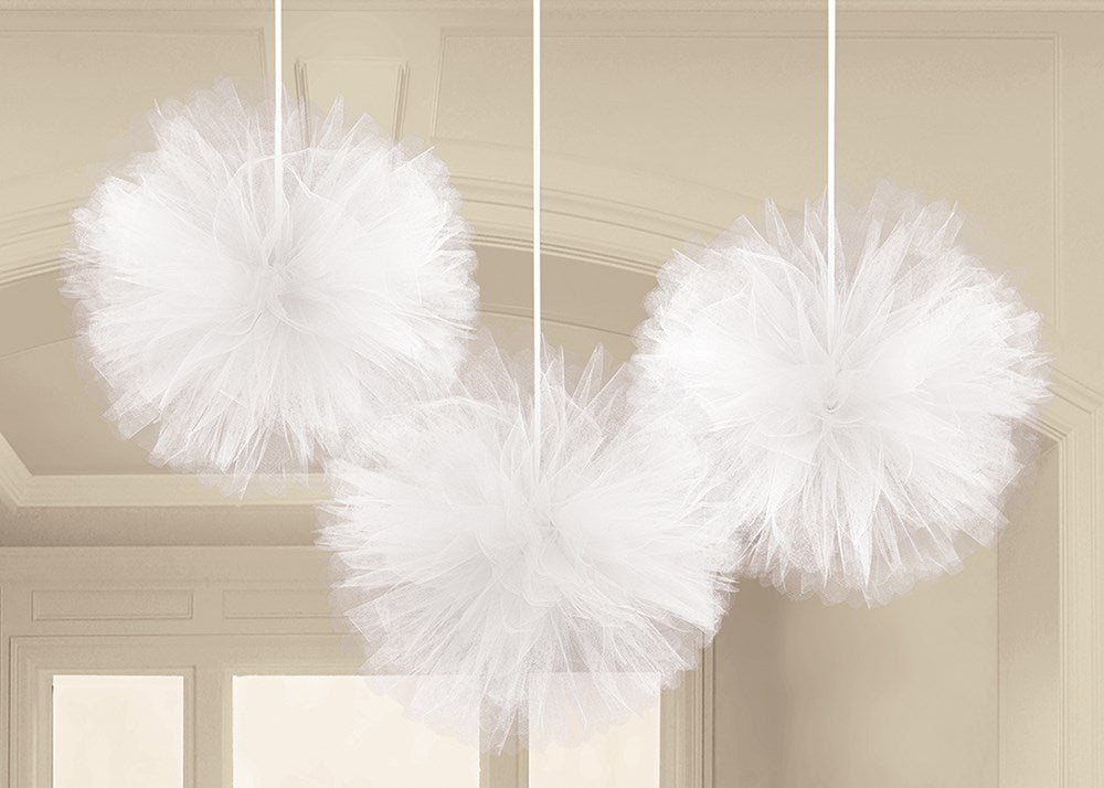 Three white fluffy tulle pom-pom decorations hanging from thin strings.