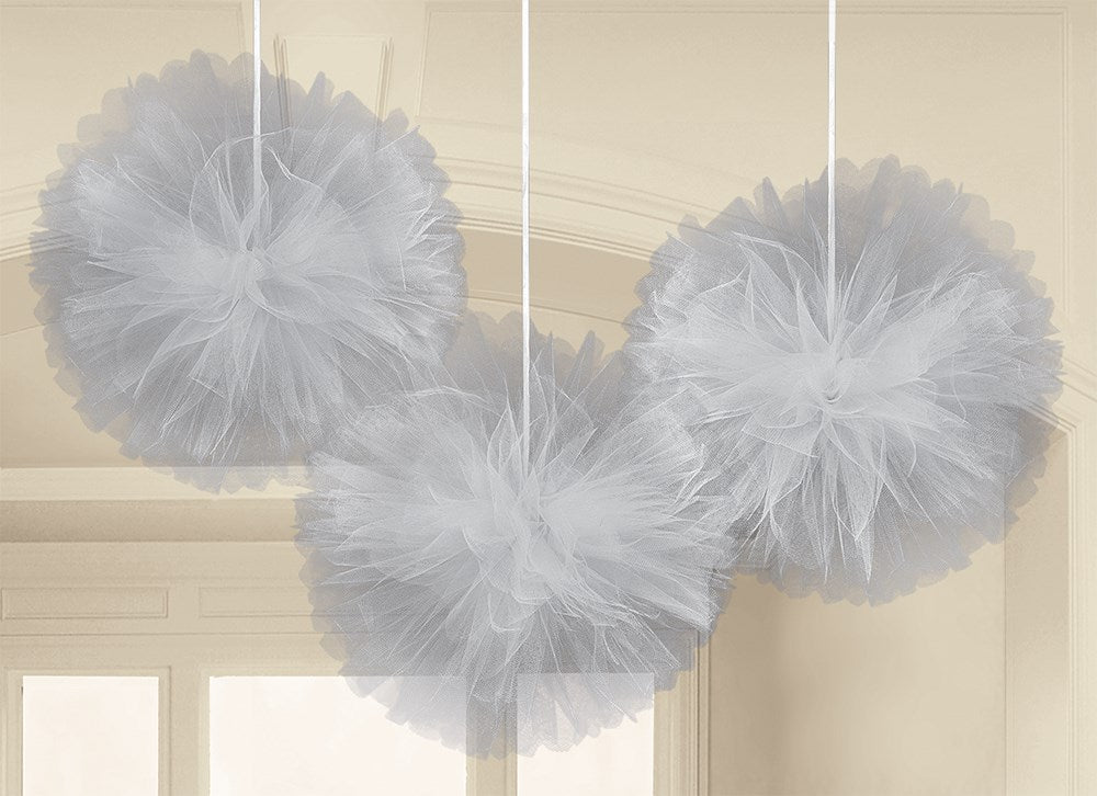 Three silver-gray tulle puff decorations hanging from white strings against a neutral background.