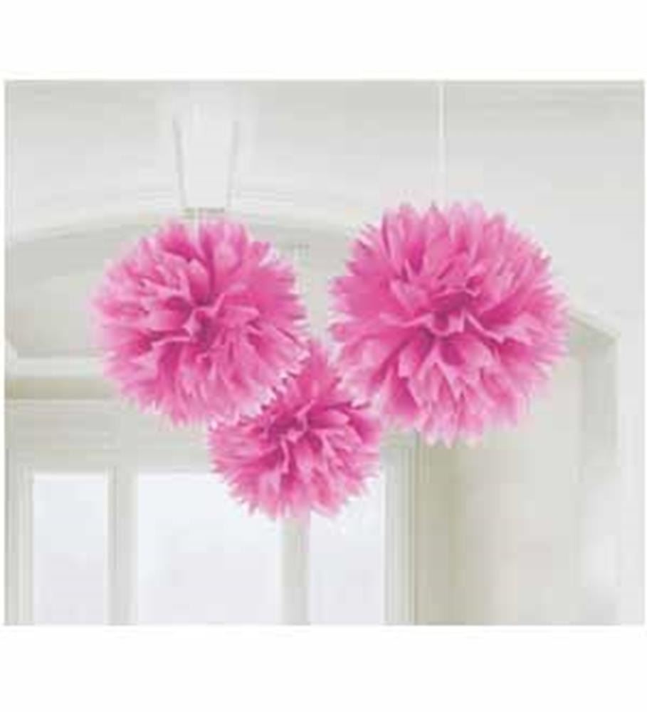 Three pink fluffy hanging pom-pom decorations in varying sizes suspended indoors.