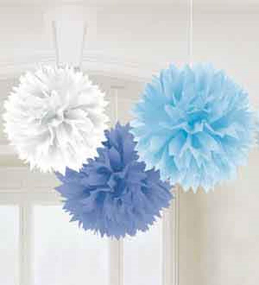 Three hanging tissue paper pom-poms in white, light blue, and dark blue for baby shower decor.