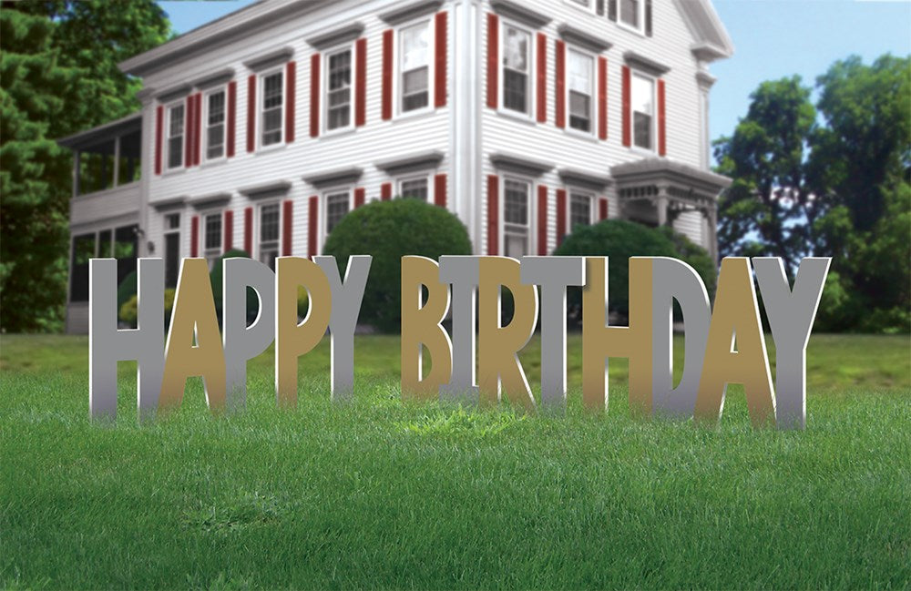 Metallic silver and gold "HAPPY BIRTHDAY" yard sign with tall block letters set on grass.