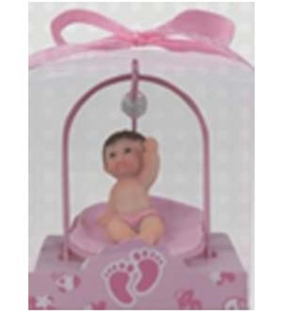 Small plastic baby figure sitting inside a pink wire carriage with a pink ribbon handle and footprint designs.