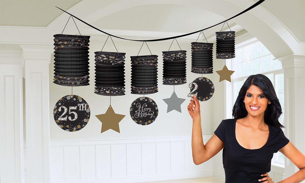 Black paper lantern garland with "25th" and star and moon shapes hanging on black string.