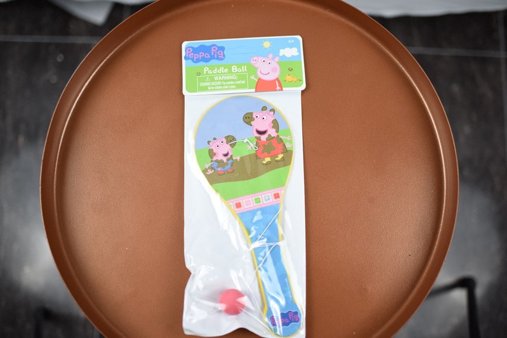 Peppa Pig paddle ball game with wooden handle and elastic ball in packaging.