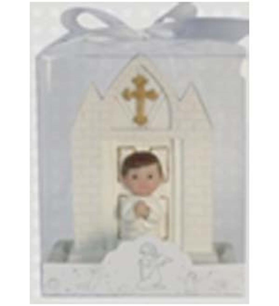 White ceramic praying girl figurine with clasped hands, dark hair, and church backdrop with gold cross, packaged in clear.