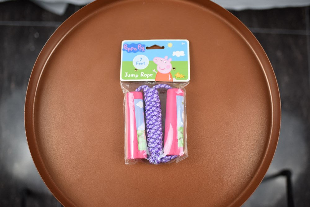 Peppa Pig themed jump rope with pink handles and purple patterned rope in clear packaging.