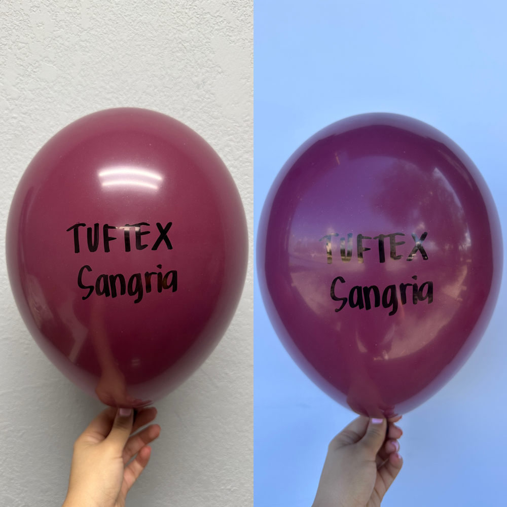 Glossy deep red latex balloons, 24 inches, branded with "Tuftex Sangria" text, inflated and held by hand.