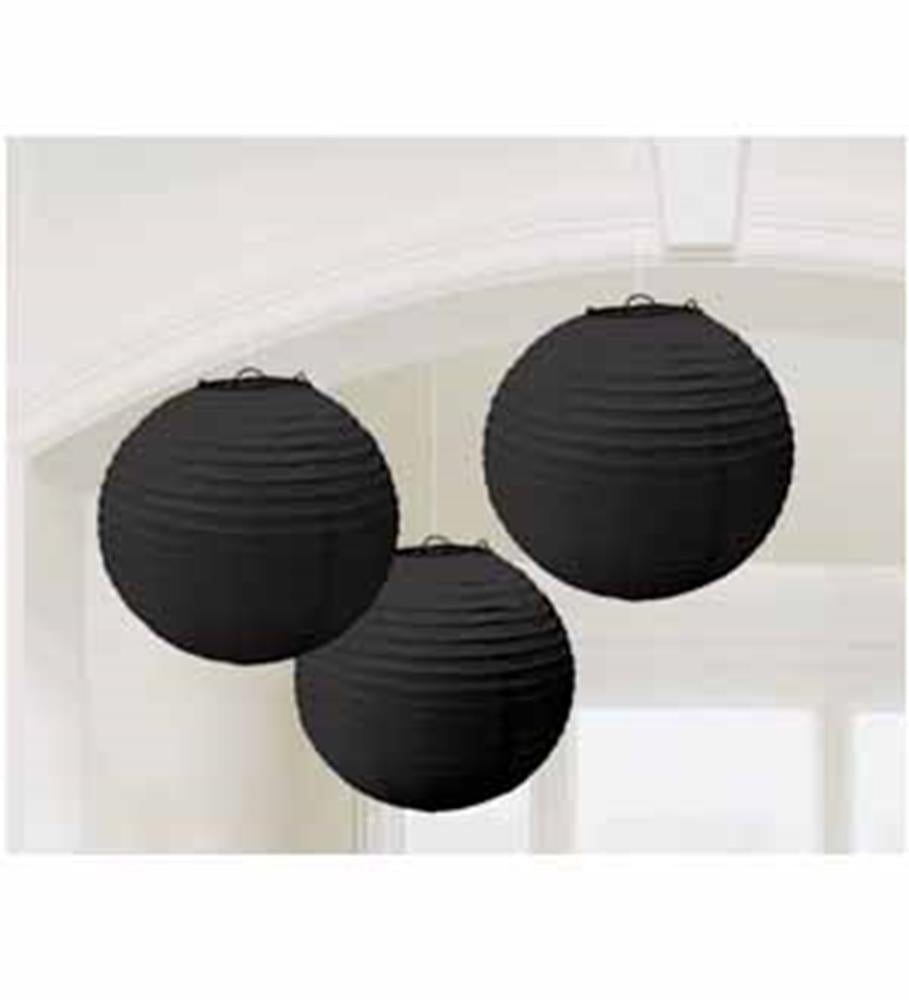 Three round jet black paper lanterns hanging indoors with ribbed texture.