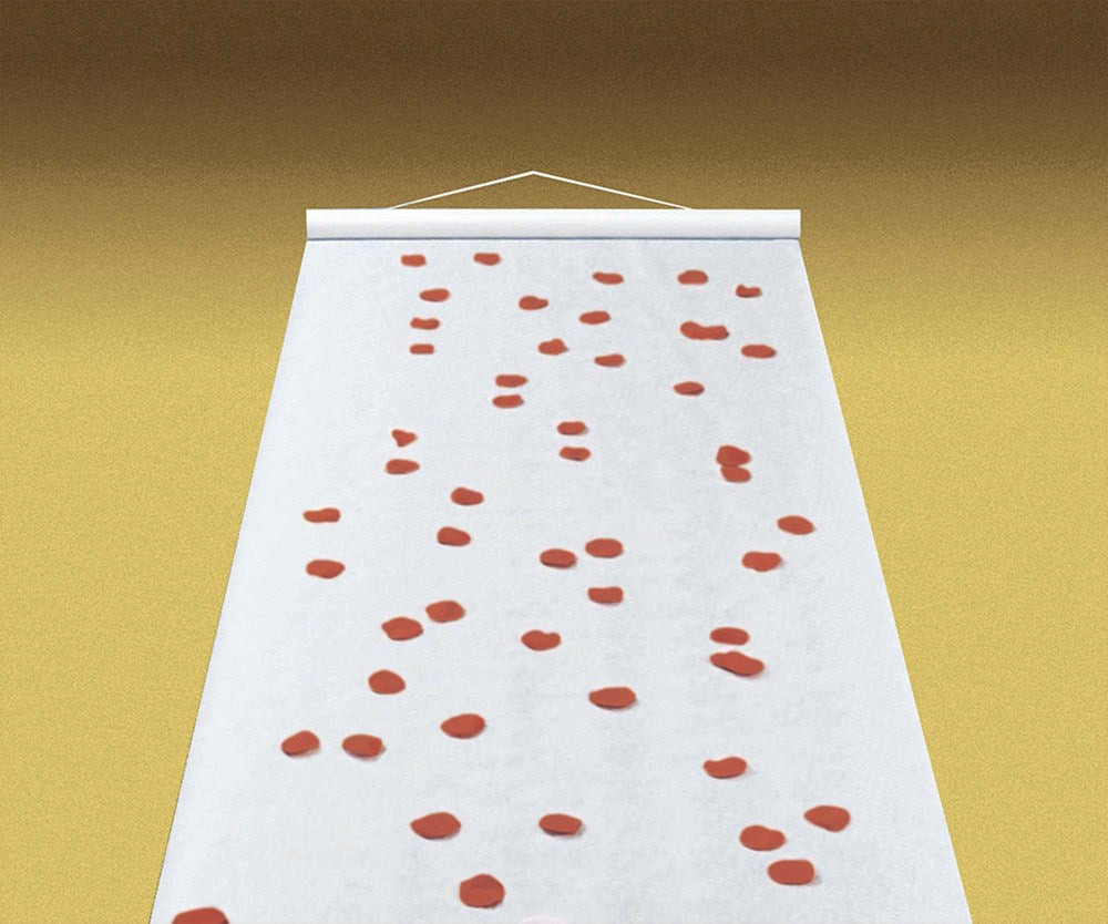 White wedding aisle runner with scattered red rose petals pattern, rolled out on gold floor.