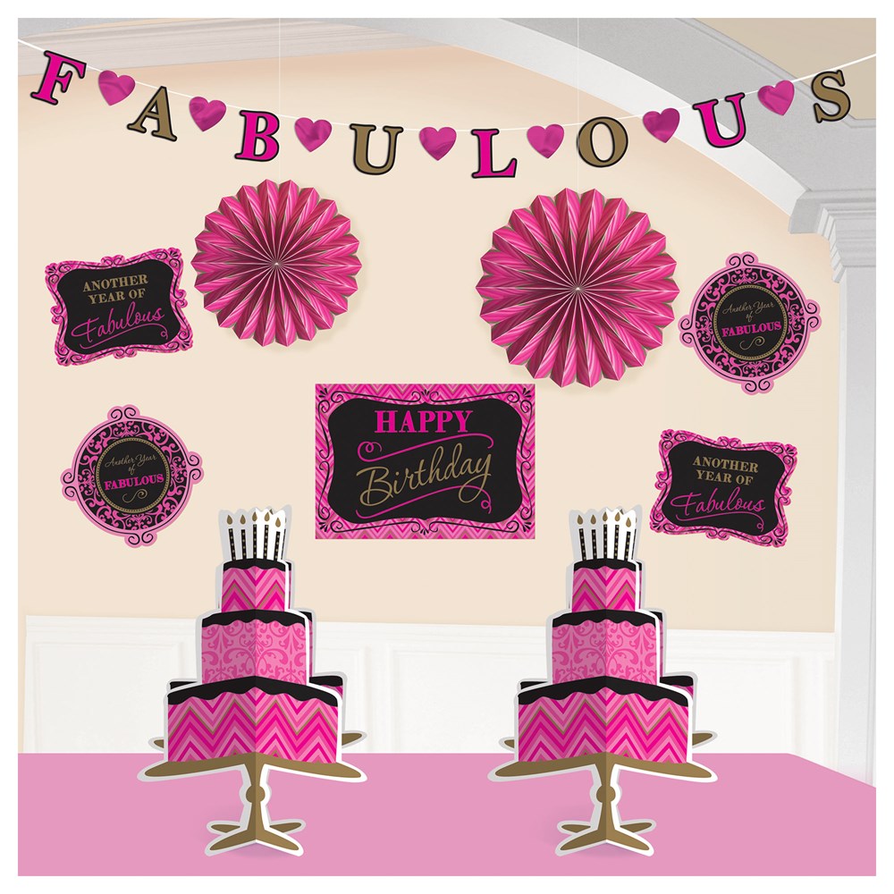 Pink and black birthday decoration set with Fabulous banner, rosettes, signs, and two-tier cakes with candles.