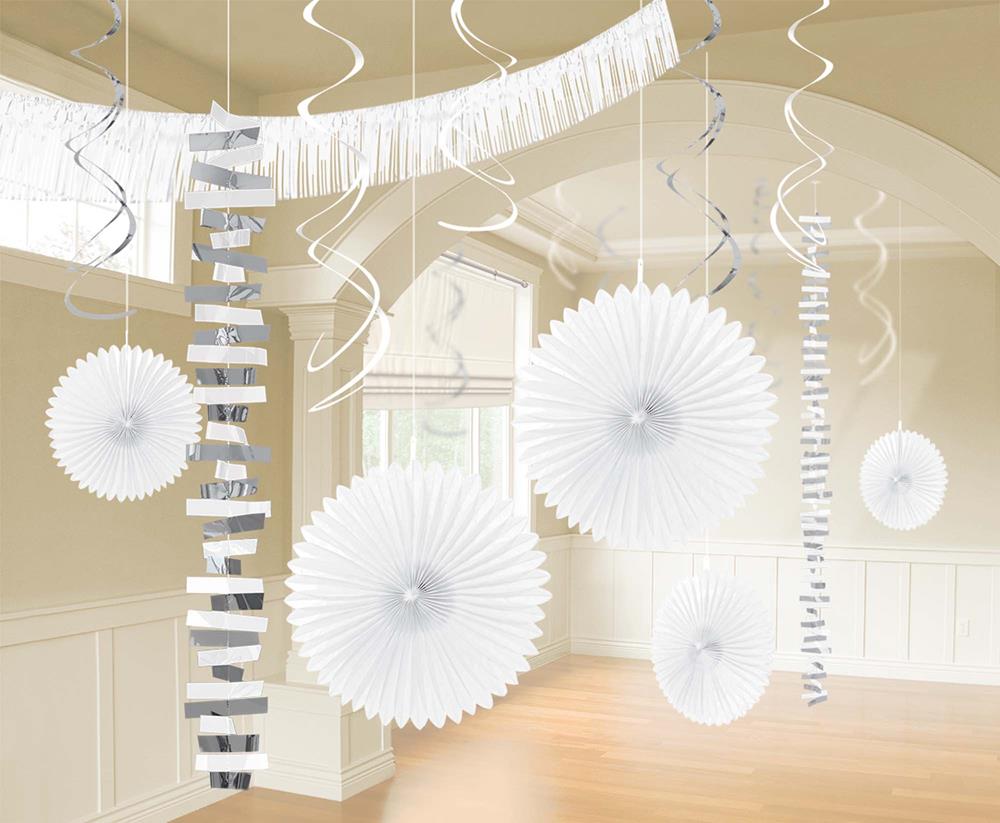 White hanging paper fans and silver spiral streamers in a beige room setting.