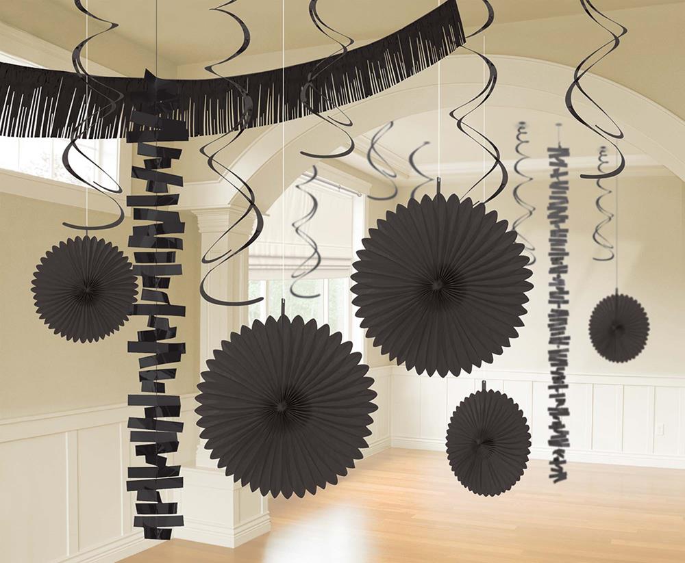 Black paper fans, garlands, and spiral streamers hanging from the ceiling for party decor.