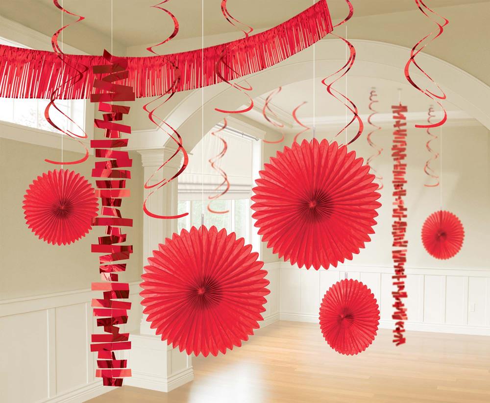 Red paper fans and spirals hanging from the ceiling for festive party decor.