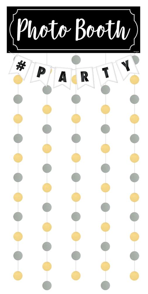 Black rectangular sign with white "Photo Booth" text above hanging gold and silver dot garlands and white pennant flags.