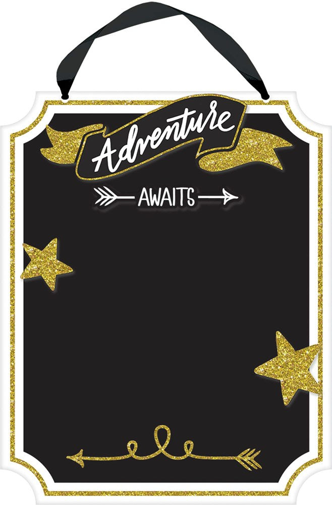 Black rectangular chalkboard sign with gold glitter stars and banners, "Adventure Awaits" text, and hanging black ribbon.