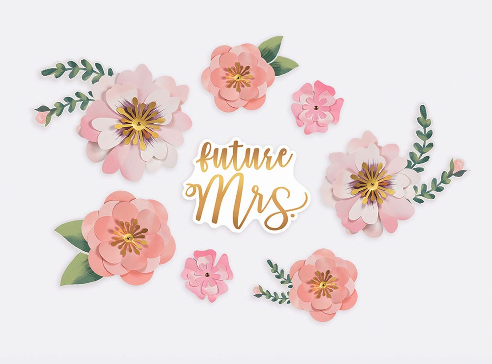 Assorted pink and peach paper flowers with green leaves and gold "future Mrs" sign centerpiece.