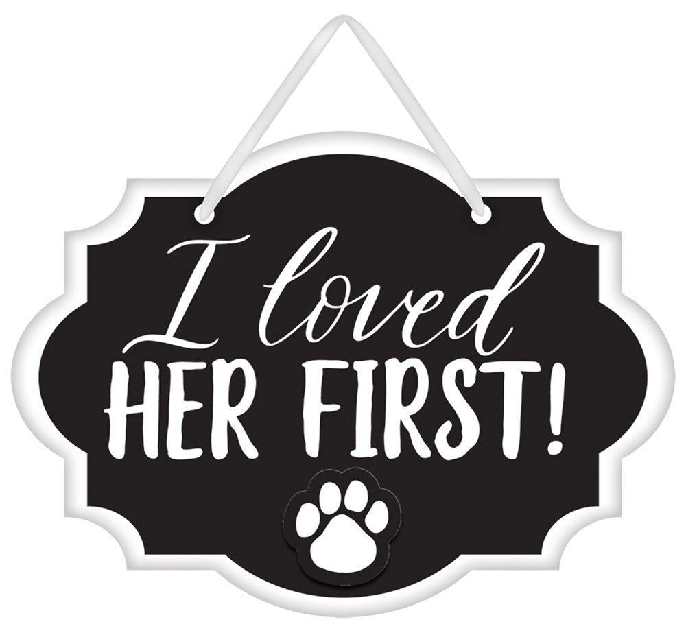 Black mini message sign with white cursive and block text saying "I loved her first!" and a white paw print, hanging by a.