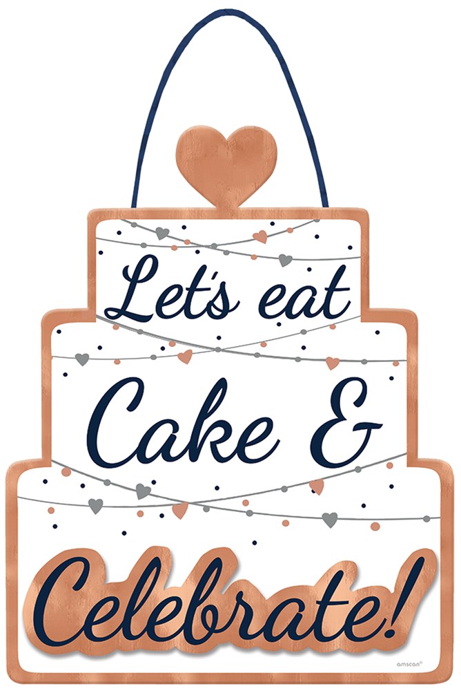 Three-tiered white cake-shaped hanging sign with navy and peach lettering saying "Let's eat Cake & Celebrate!" decorated.