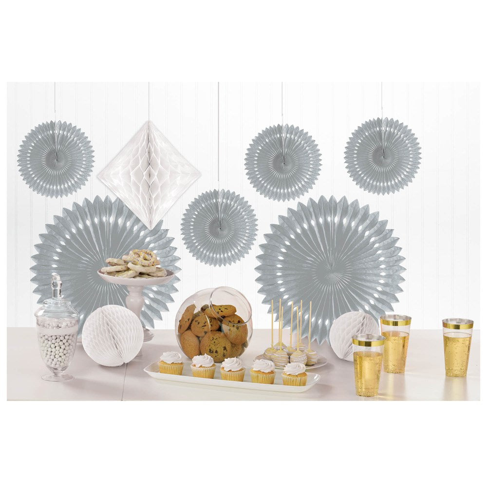 Silver paper fan decorations in various sizes and shapes with matching silver cups and plates arranged on a white table.