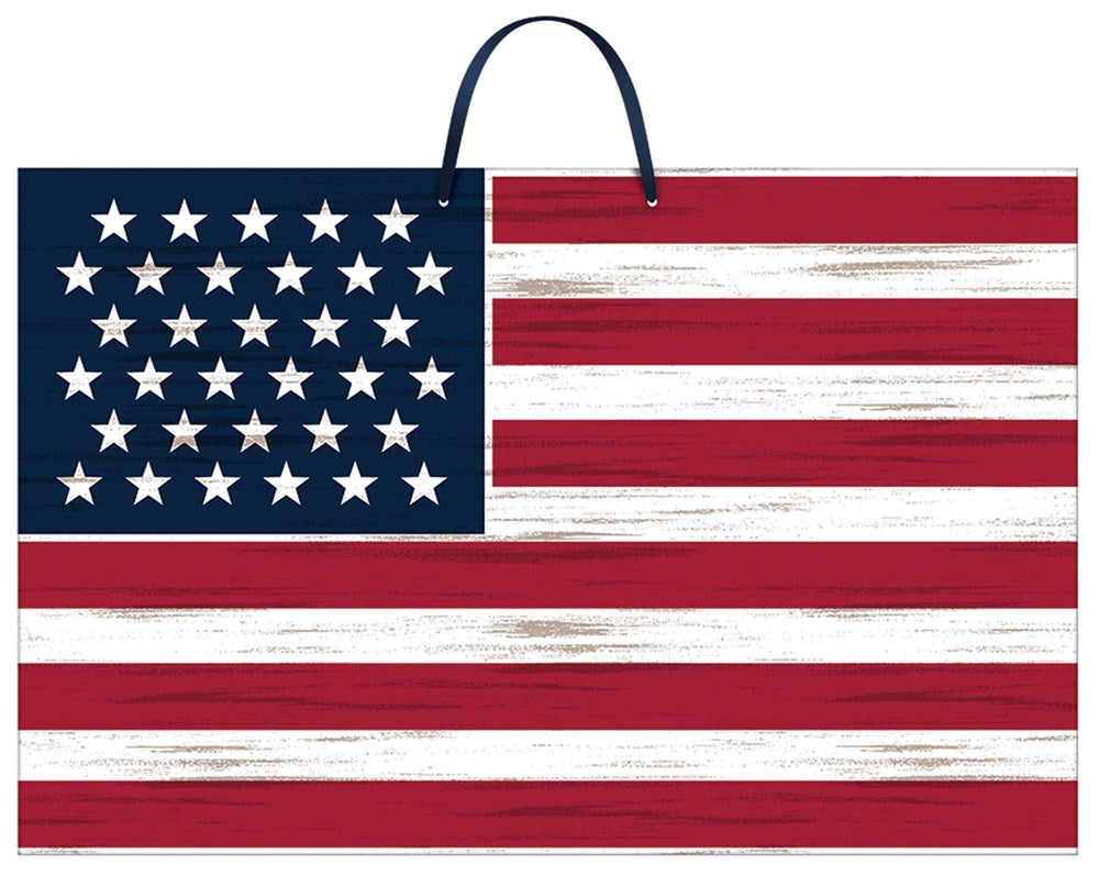 Wooden American flag sign with distressed red, white, and blue paint and a black hanging strap.