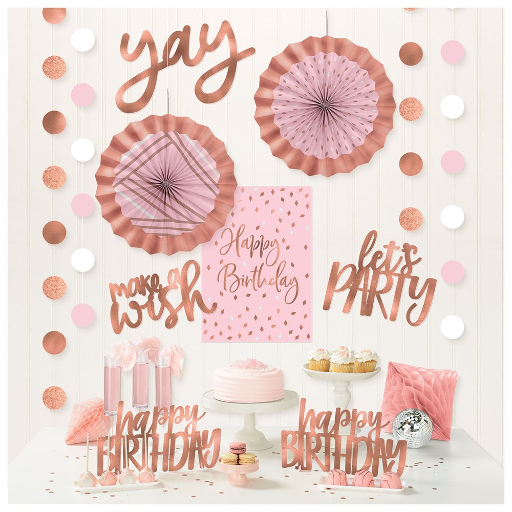 Blush pink and rose gold birthday decorating kit with paper fans, confetti garland, cupcake toppers, cake, and celebratory.