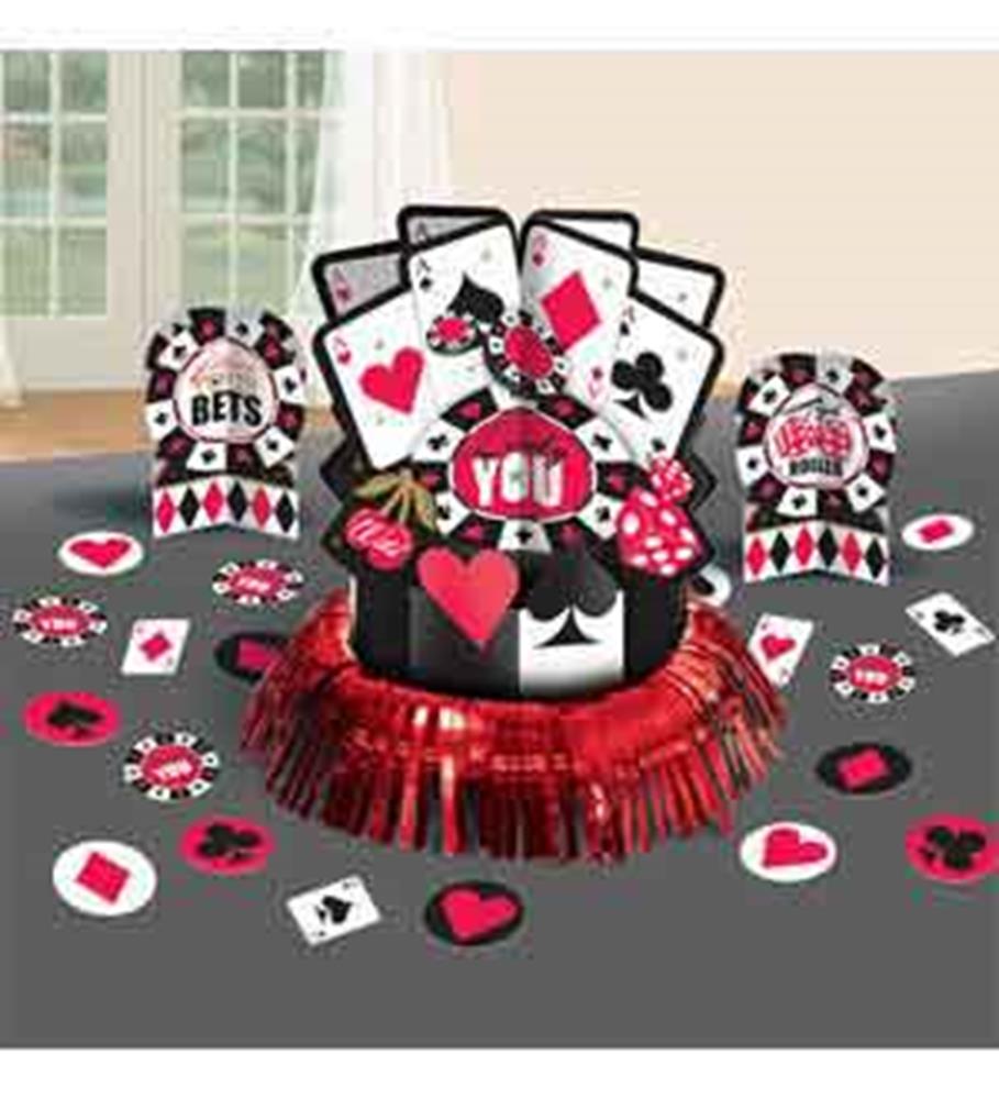 Casino-themed table centerpiece with playing cards, poker chips, and red-black fan base on gray table.