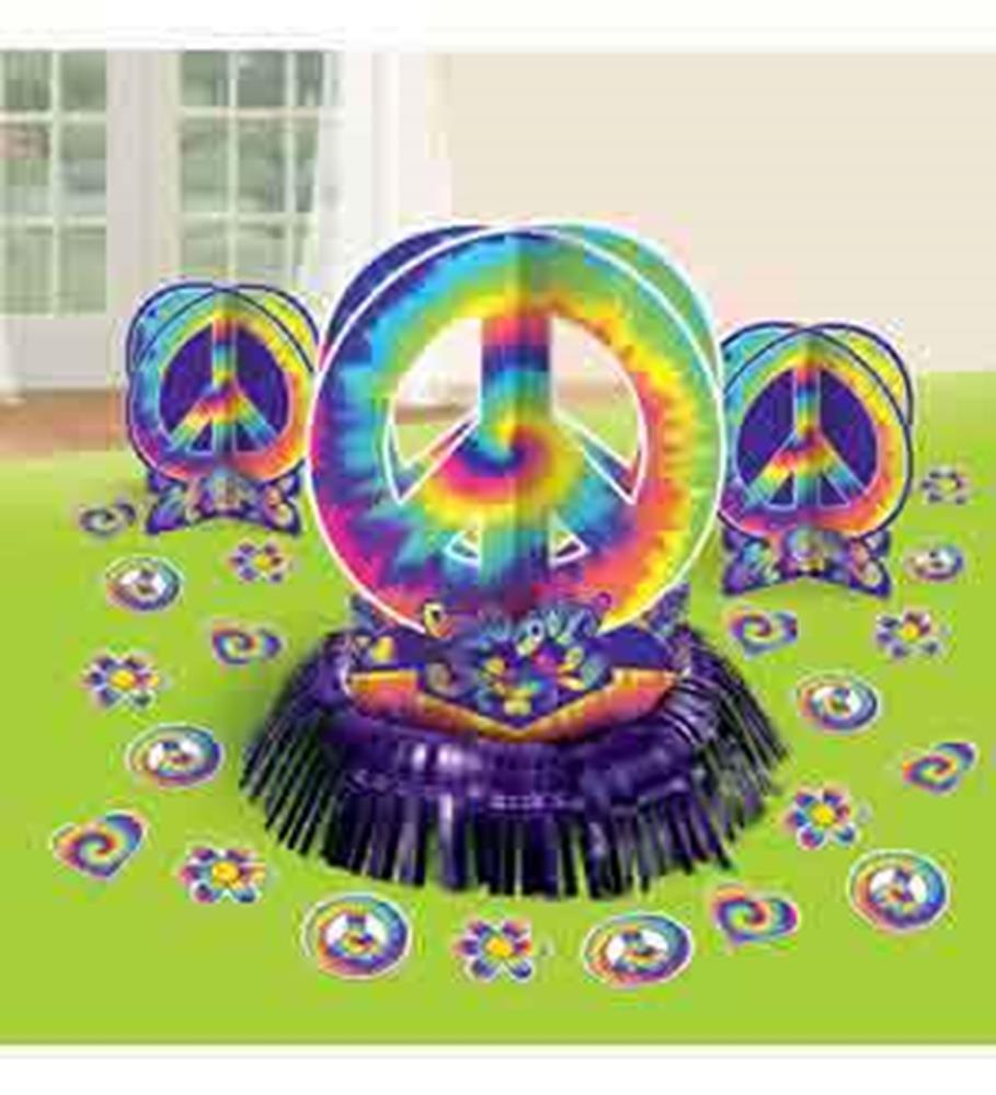Tie-dye peace sign centerpiece with matching table scatter in vibrant rainbow colors on green tablecloth.