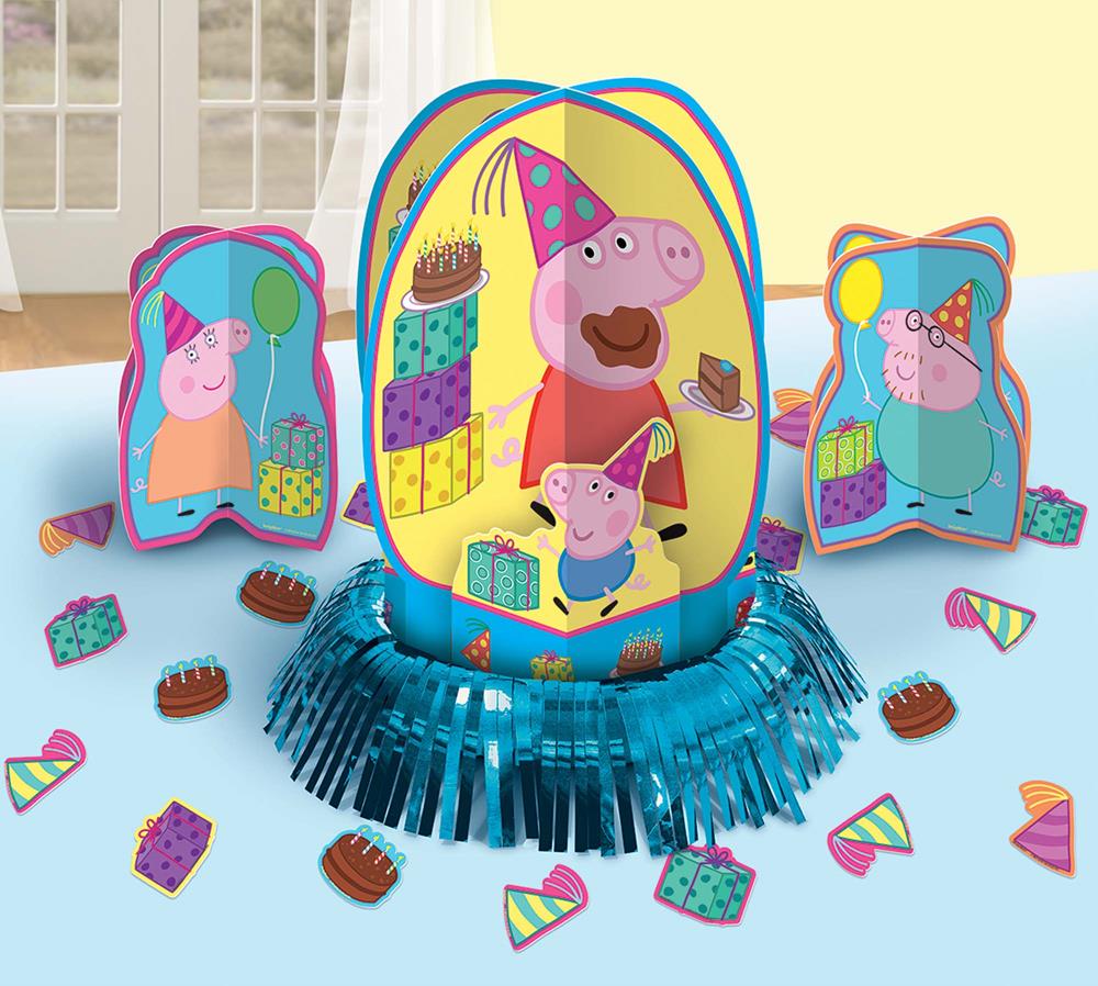 Peppa Pig themed table centerpiece with party hats and cupcake decorations on blue tablecloth.