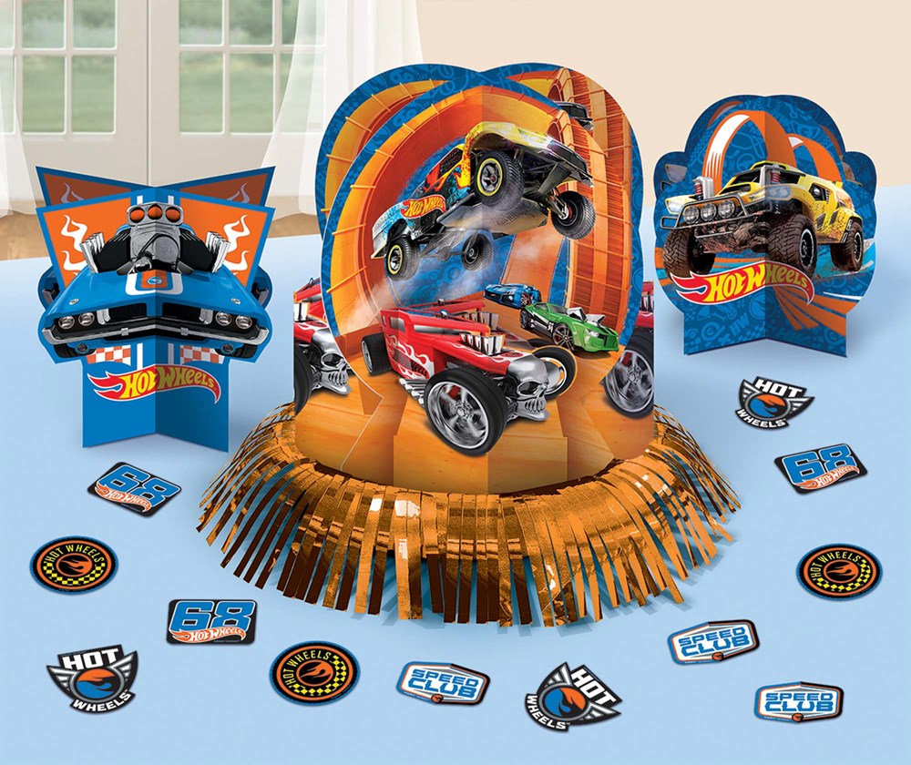 Colorful Hot Wheels-themed table centerpiece with 3D monster trucks and orange fringe base, surrounded by assorted circular.