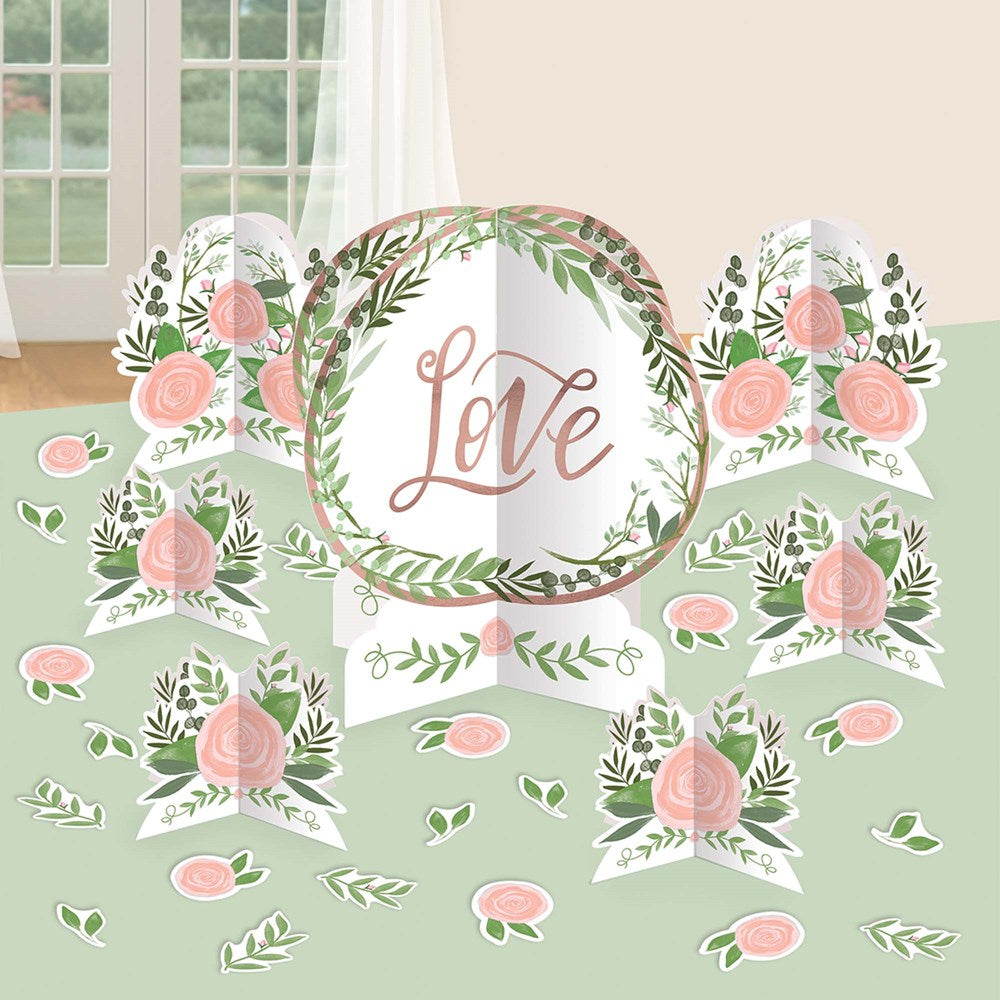 Round centerpiece with "Love" in pink script surrounded by green leaves and pink roses on a white backdrop.