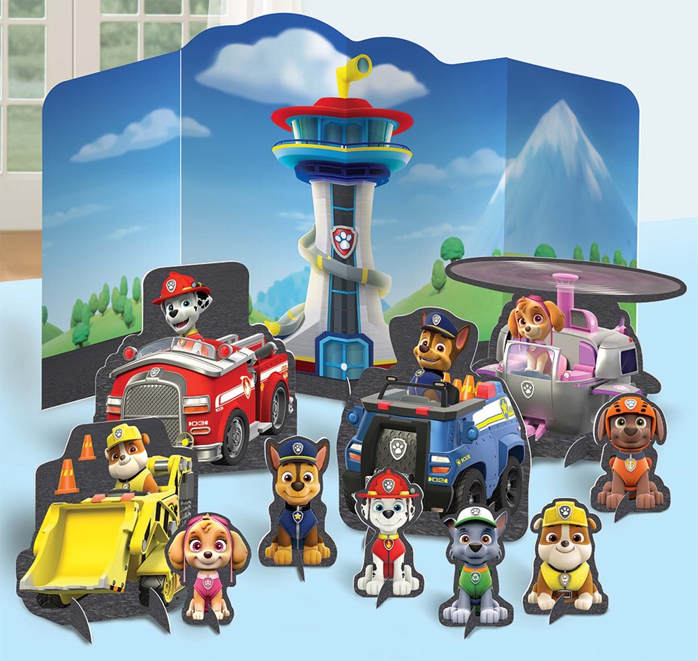 Colorful Paw Patrol table centerpiece with 3D characters, lookout tower, and themed backdrop.