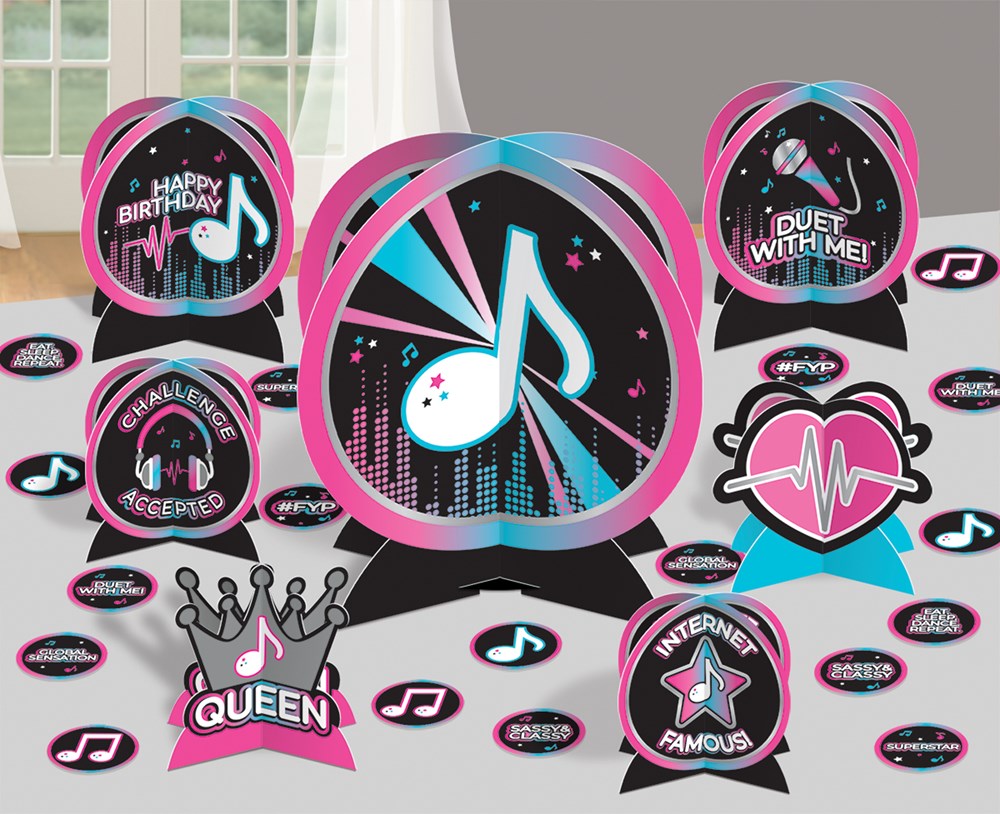 Colorful table decorations with music note, crown, star, and heart designs in pink, black, blue, and white for birthday.