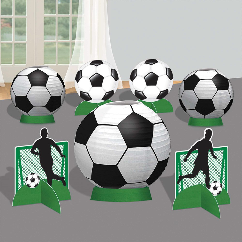 Black and white soccer ball centerpiece with matching balloon weights and soccer player cutouts on green bases.