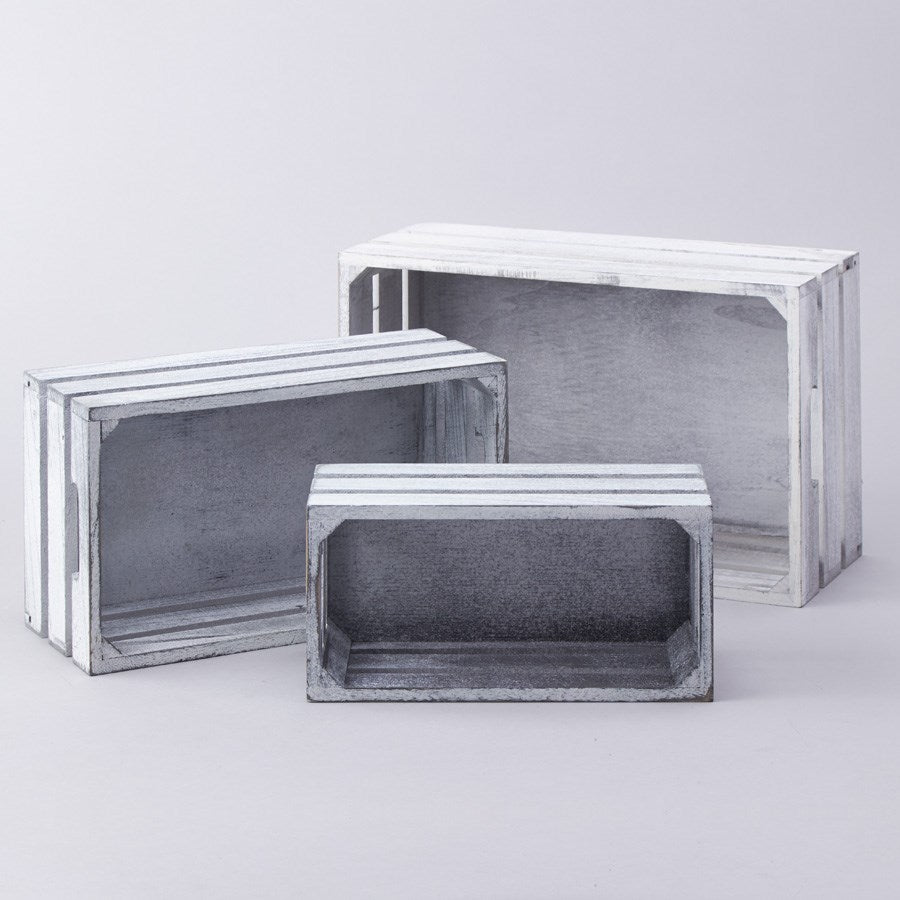Set of three white wooden crates in varying rectangular sizes with open fronts and slatted sides.