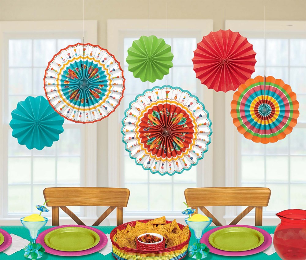 Set of six colorful paper fan decorations in red, teal, green, orange, and multicolor patterns, hanging above a festive.