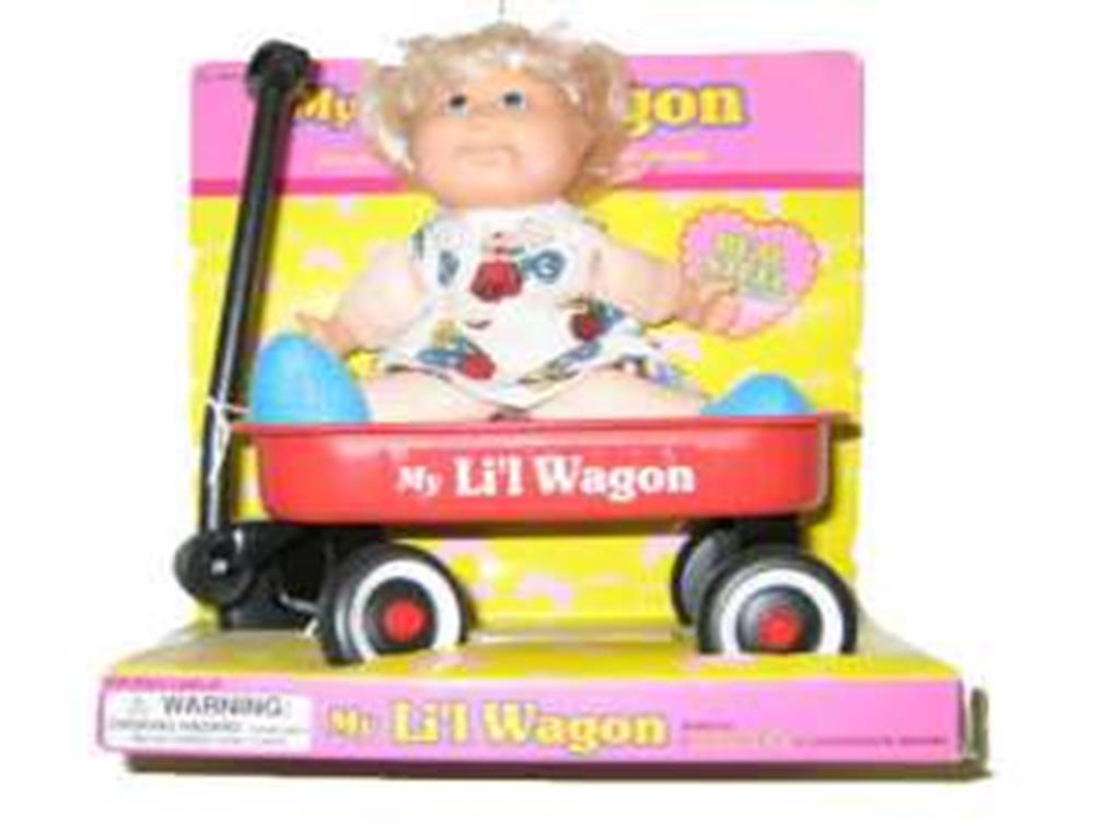 Red metal wagon with black handle and white wheels holding a blonde doll in a white dress with colorful pattern.