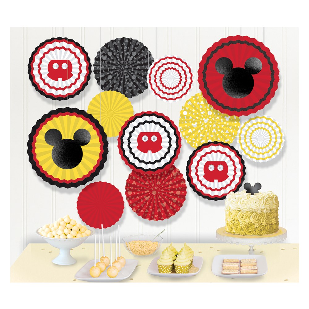 Red, yellow, black, and white layered paper fan cutouts featuring Mickey Mouse silhouettes and iconic patterns, arranged on.
