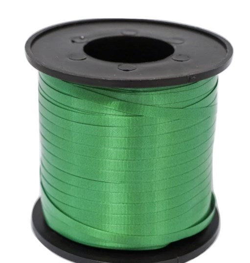 Emerald green glossy curling ribbon tightly wound on black plastic spool.